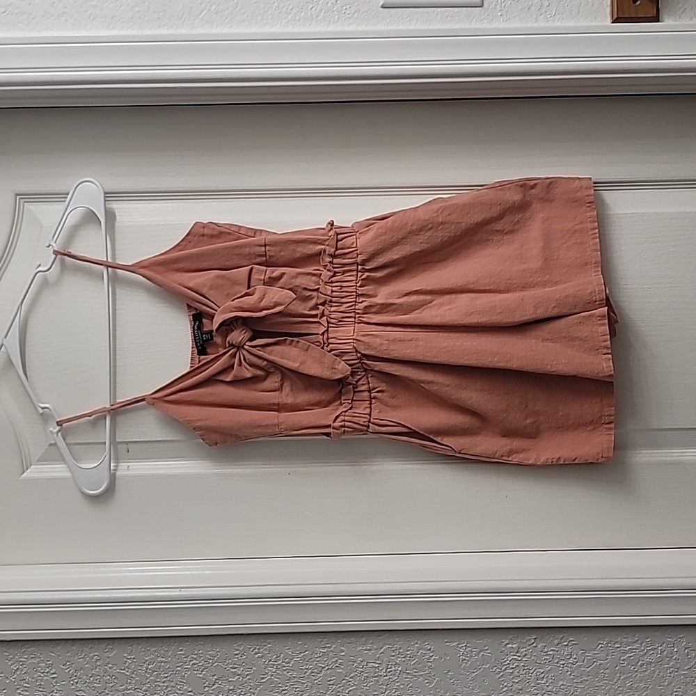 Blush pink mini romper with bow tie and cutout hole and pockets, size XS